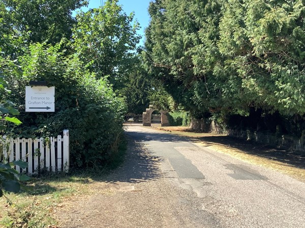 Tucked into the hedges a sign points the way to the Manor