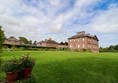 Back of the house with expansive lawned gardens.