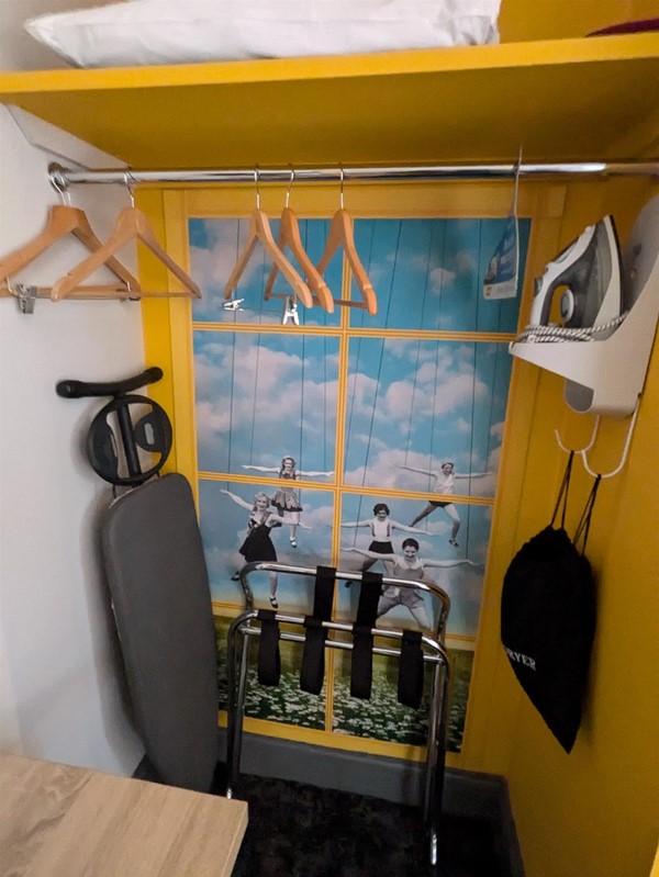 Image of wardrobe with iron, ironing board and hangers