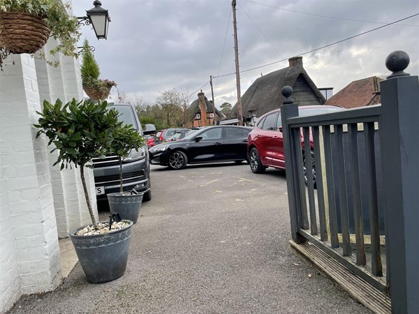 Image of a carpark and a grey fence.