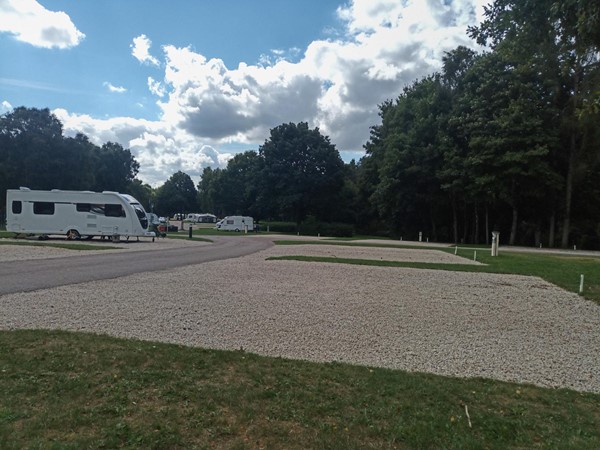 Pitches down one side of the roadway, showing gravel hardstandings with grass in between.