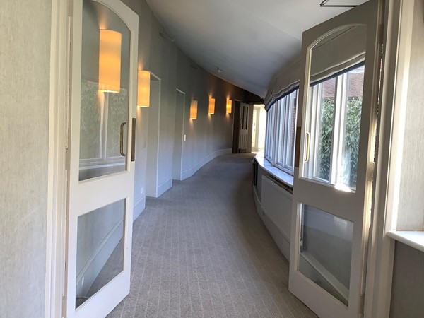 Image of a hallway with white doors and windows