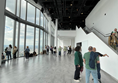 Image of a group of people in a large room with windows