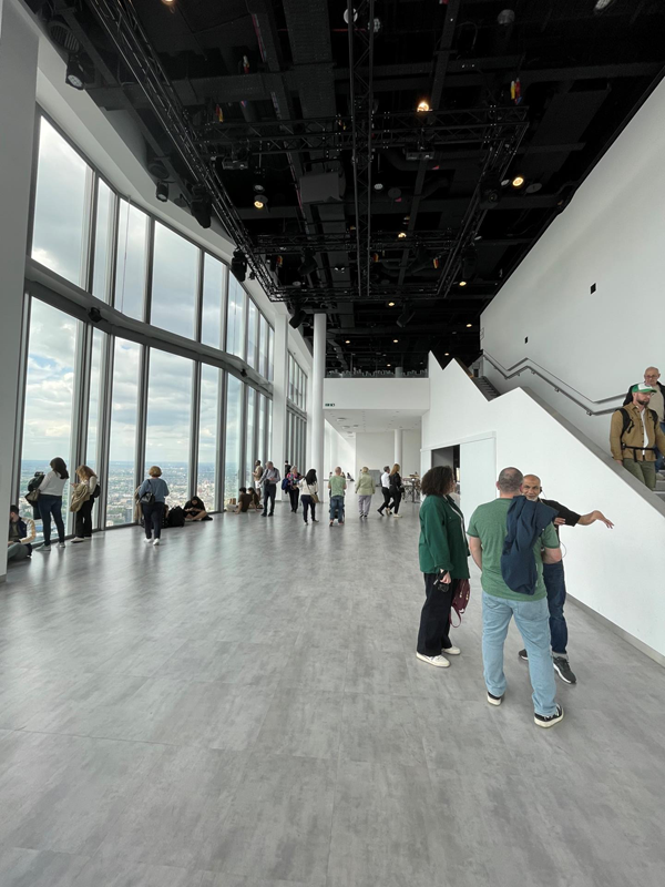 Image of a group of people in a large room with windows