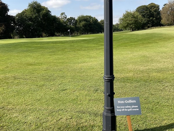 Image of a sign on a pole in a golf course