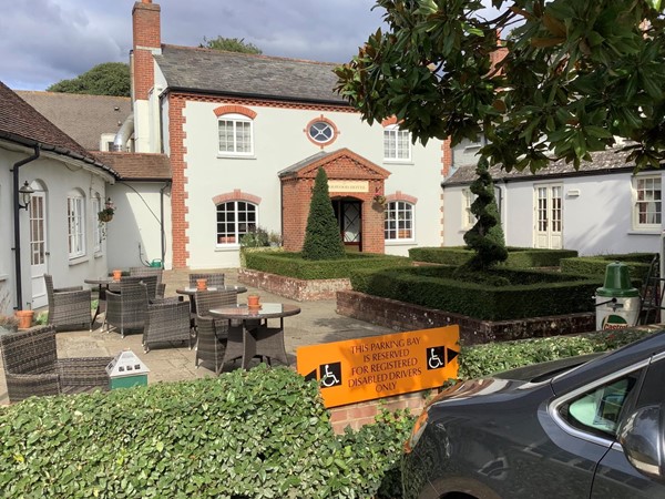 Image of a white building with an orange sign