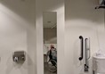 Image of a person in a wheelchair taking a picture of themselves in a mirror