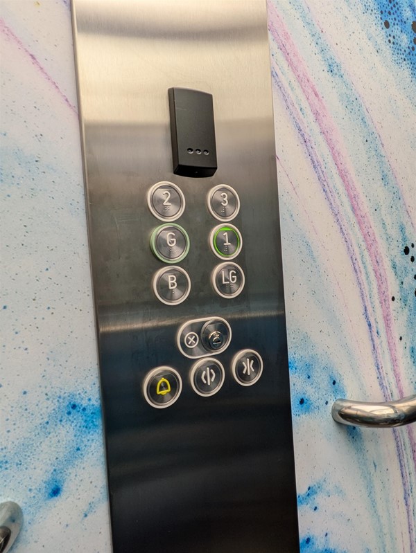 Image of lift button panel. The lift buttons have Braille Markings