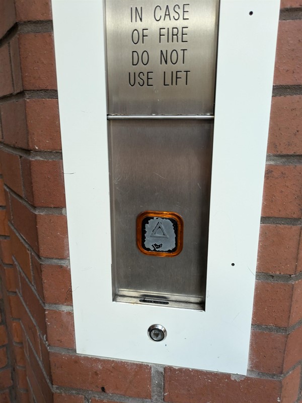 Image of lift call button with braille markings