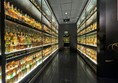 The whisky collection with floor to ceiling bottles of whisky on their glass shelves.