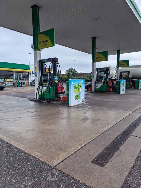 Image of a petrol station with a green and white gas station