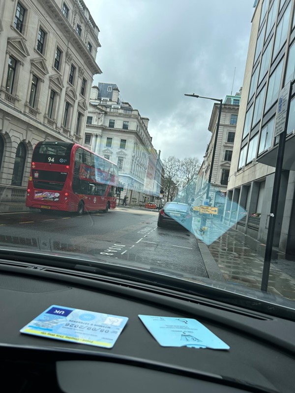 Image of a bus going down a road through a window