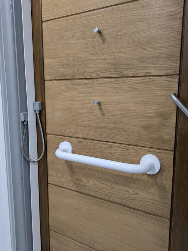 Image of the grab rail on the door inside the disabled toilet.