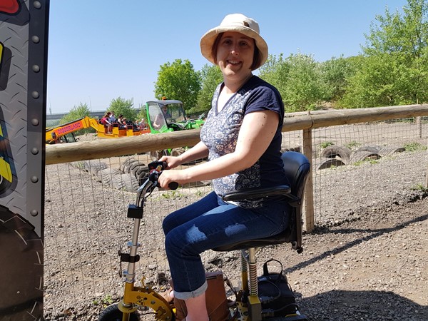 Using a scooter at Diggerland Kent with two rides in the background