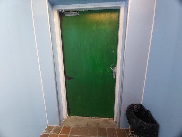 Image of the door leading out of the accessible toilet.