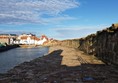 Picture of a path by some water leading to some houses