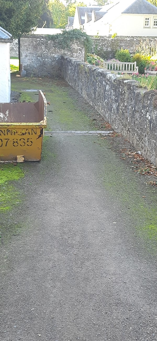 Image of a yellow skip on a path.