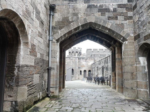 Cobbled path going through castle archway.