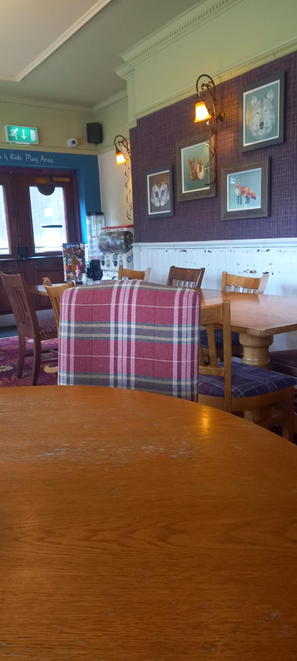 View of interior and door to children's play area from a round wheelchair accessible table.