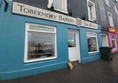 Image of a blue building with a sign on the side