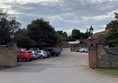 Image of a parking lot with cars parked in front of a brick wall