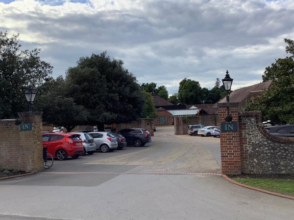 Image of a parking lot with cars parked in front of a brick wall