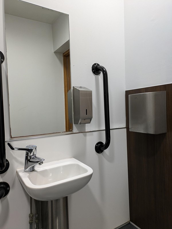 Image of the sink and mirror in the accessible toilet