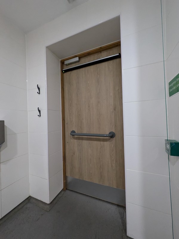 Image of the inside of a door in the accessible toilet - the door has a grab rail