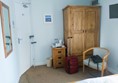 Image of chair, wardrobe and mirror in guest bedroom