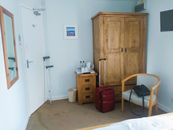 Image of chair, wardrobe and mirror in guest bedroom