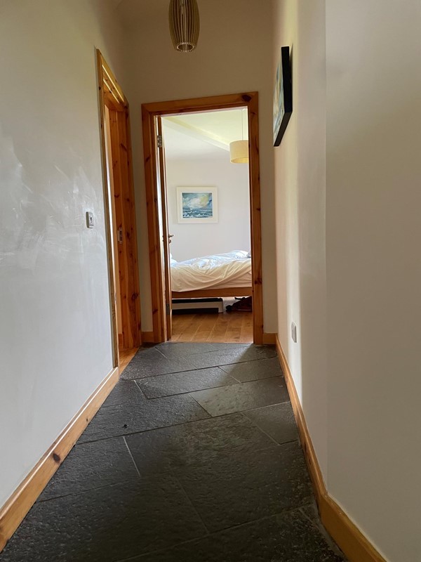 Image of a hallway with a bed and a wood frame