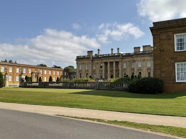 Image of a large building with a lawn and a road