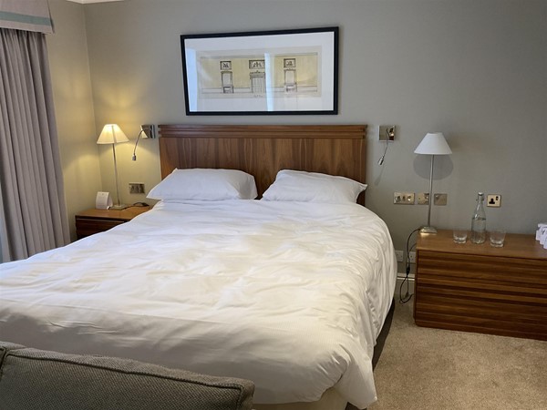 Image of a bed with a wood headboard and a lamp