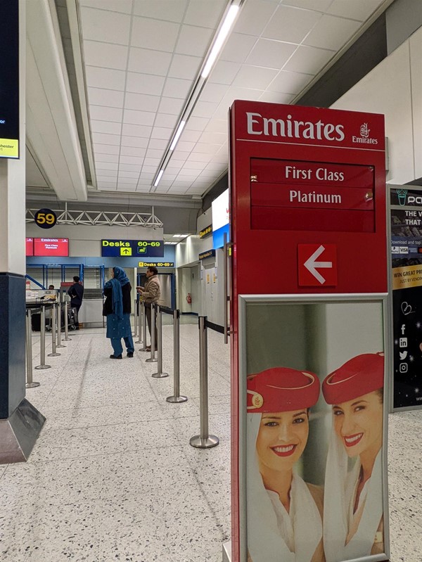 Image of the Emirates queueing area. A large red sign showing to flight attendants