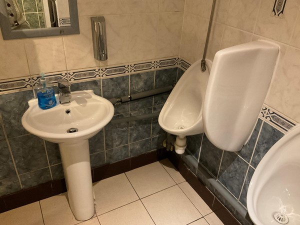 Image of a bathroom with a sink and urinals