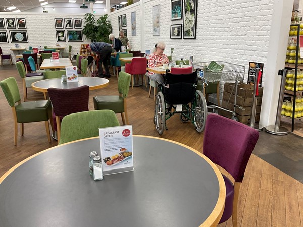 Image of tables, people and chairs in a room