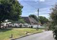 Picture of a road with a pub called The Bell in the distance