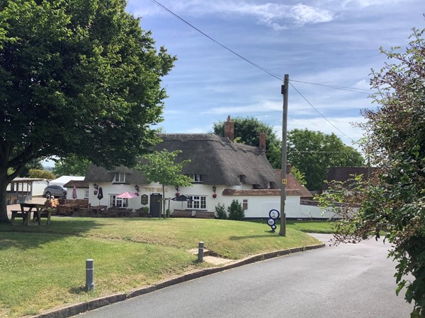 Picture of a road with a pub called The Bell in the distance