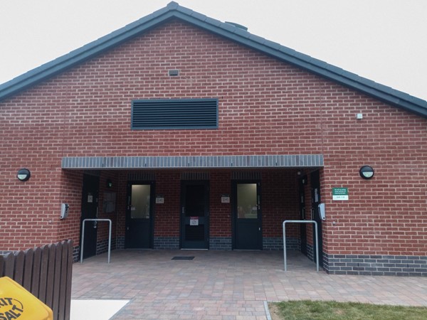 Entrance area to the facilities block, with wide open paved surface.