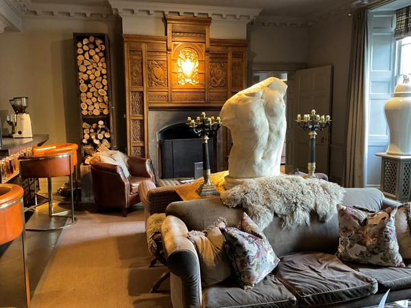 Image of a room with a fireplace and a statue on the back of a couch