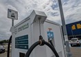 Image of a white electric car charging at a car park emitting zero emissions and promoting sustainable transportation.