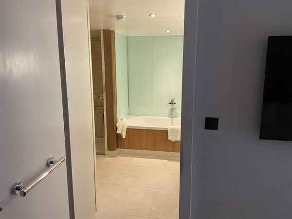 Image of a bathroom with a bathtub and a door