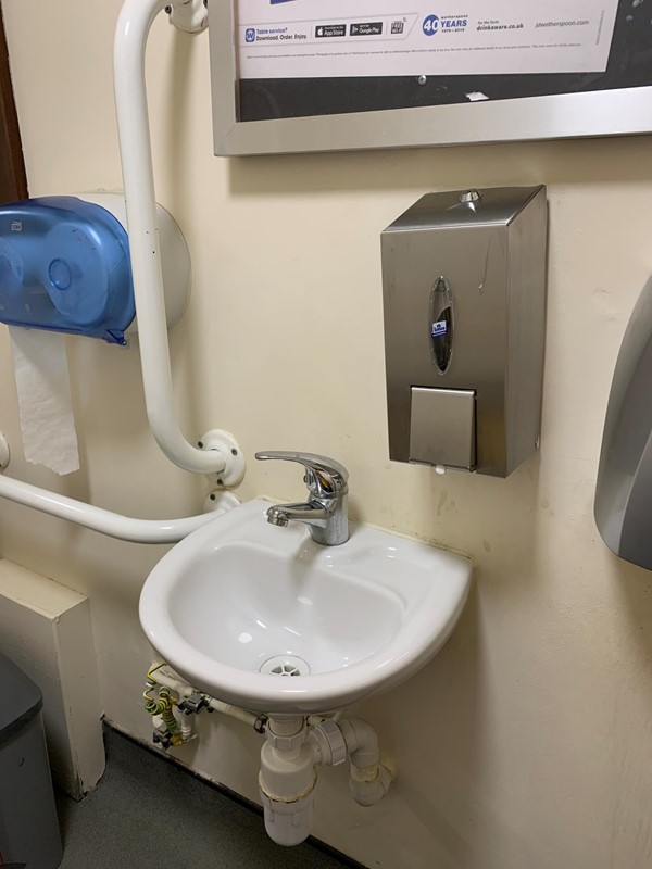 View of sink close up, vertical handrail on left hand side