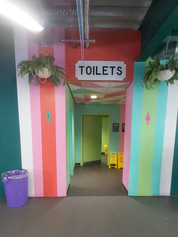 Image of a colourful hallway with a sign