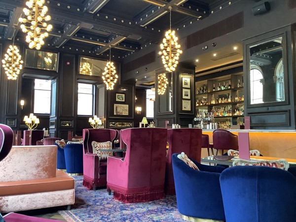 Red sofas and blue tub chairs in velvet in a bar lounge