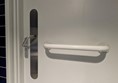 Image of the accessible toilet door with a grab rail