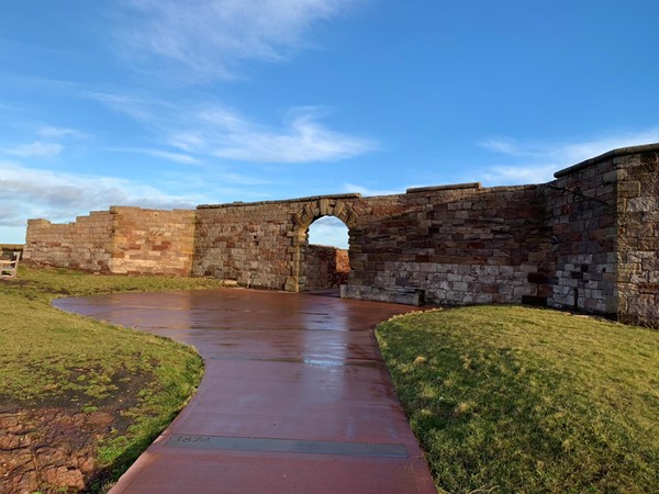 A flat path and a stone wall with archway