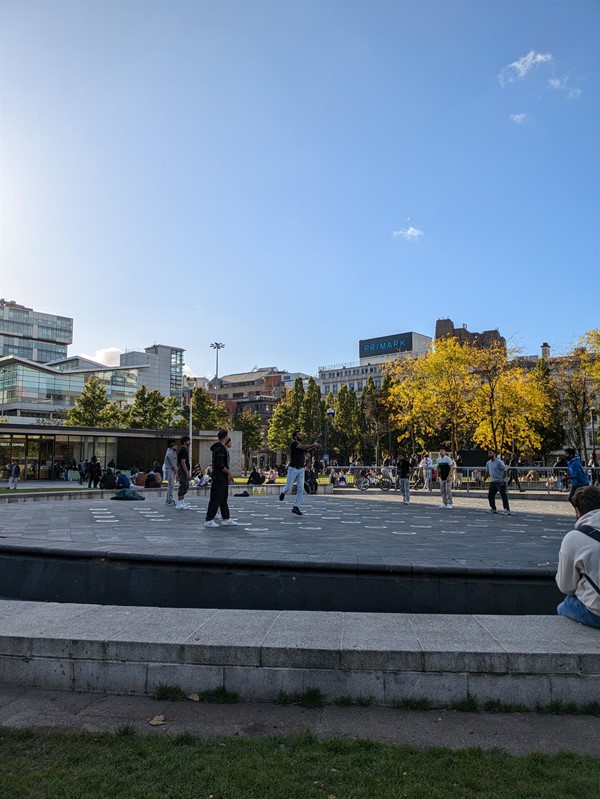 Image of the fountains, they're off and several men are seen throwing a bakk around.