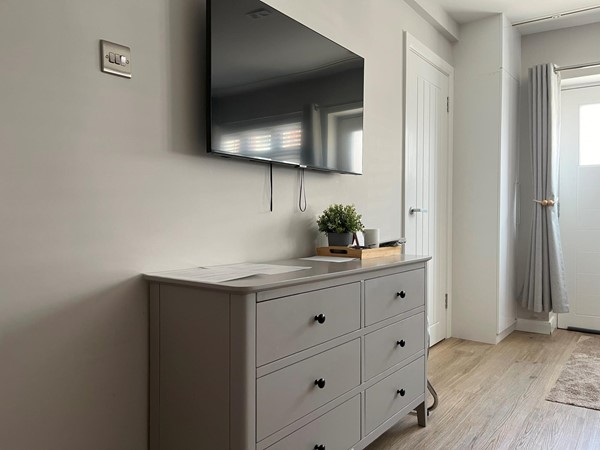 Image of the chest of drawers and TV in the accessible bedroom.