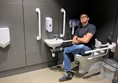 Image of a man sitting on an accessible toilet